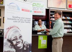 At Knowles Spar in KZN, Roelf Venter, Chairman of Spar Guild, receives the Instant Money payment sent by Sim Tshabalala.