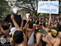 PHILIPPINES, Manila : Nude members of a university fraternity make their way through a crowd of students during the traditional 'Oblation Run' at the University of the Philippines campus in suburban Manila on 15 December 2009 to protest against the massacre of journalists in the southern part of the country. AFP Photo/Jay Directo