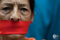 Venezuela, Caracas: A woman wears a gag as journalists and workers of Venezuelan media, demonstrate in support of 32 radios and two TV channels closed by the government a year ago, in front of the private radio network Belfort National Circuit (CNB) in Caracas on August 1, 2010. AFP photo/Miguel Gutierrez