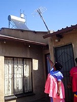A Viva Street beneficiary pointing at a solar geyser.