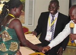 A participant receives a certificate of attendance after the two day training for Small & Medium Enterprises (SMEs) in Gulu