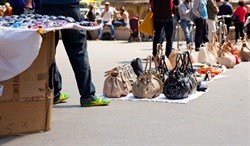 Counterfeit goods such as bags and sunglasses sold on sidewalks and market stalls.