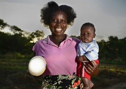 Priscilla and her son in Zambia with a solar light. These lights are bringing clean, safe, affordable lighting to homes for the first time. (Image: Patrick Bentley)