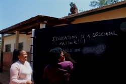 Dikeledi Magadzi, the MEC of Education in Limpopo writes a message on a chalkboard with Thandi Manqana, Engen CSI co-ordinator Gauteng.