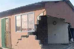 A gaping hole in one of the houses that was damaged in Khuma after a earthquake outside Orkney in North West. Few people, it seems, are insured against losses and will have to pay the repair costs themselves. Image: