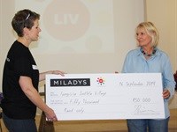 Philippa Feher, MILADYS Marketing Manager, hands over a cheque to LIV Village Co-founder, Joan Smith.