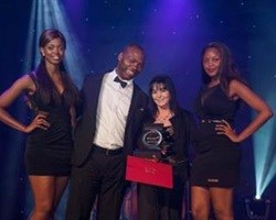 Angela Dick receives the Outstanding Woman in Business Award from Buyani Zwane, Founder and CEO of Breakthrough Development. [Image: Julian Cole.]