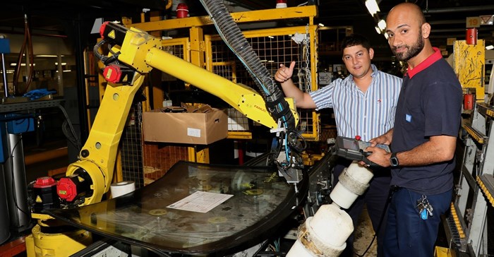 NMMU Mechatronics Engineering graduate, Nathan Kops (left) is now a full-time employee at GMSA. Inspecting one of the robotic systems in the Struandale assembly plant with him, is automation technician, Rais Salie.