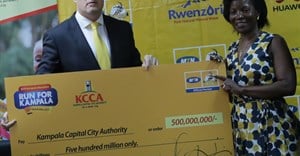 MTN’s CEO Brian Gouldie handing over a dummy cheque of MTN Marathon proceeds worth shs.500 million to executive director of Kampala Capital City Authority (KCCA), Jenifer Musisi.
