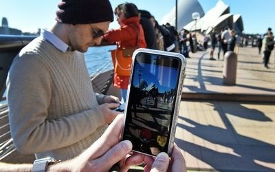 Dozens of people gather to play Pokemon Go in front of the Sydney Opera House, Australia, on Friday.<p>Picture: