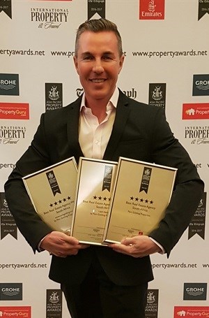 Basil Moraitis, Pam Golding Properties area manager for the Atlantic Seaboard, seen with Pam Golding Properties awards for Best Real Estate Agency, Best Real Estate Agency Marketing and Best Real Estate Agency Website.