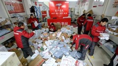 Deliverymen sort through packages of goods at a collection centre in Beijing on 9 November 2016 |