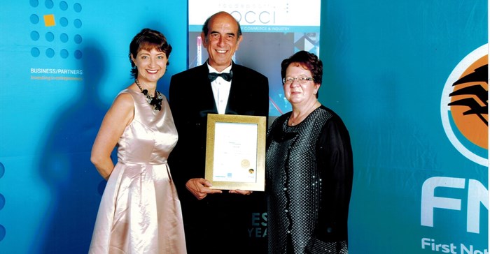 Mike Myers (centre), receives The Gold Winner Award for Tourism from Michelle Geraghty, FNB Regional Head, Gauteng South West (left) and Marietjie Esterhuizen, ROCCI President, (right).