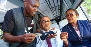 Sicily Kariuki, Public Service, Youth and Gender Affairs secretary (right) and Simon Kimutai, Matatu Owners Association chairmen (left), demonstrate the ease of using her Huduma Card to pay for services in Kenya.