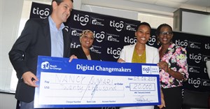 Tigo Tanzania Managing Director, Diego Gutierrez (right), hands over a dummy cheque to Nancy Sumari, (right, in white).