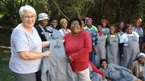 Adéle’s Mohair near Fish River Mouth has been providing employment for rural communities for over 30 years. Here founder and Agri EC Adéle Cutten (left) and long-time employee Liz Dyakala (right) inspect the team’s new uniforms. (Image: Supplied)
