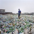 A man sorting a sea of plastic bottles at one of the Wecycler hubs in Lagos, Nigeria. Most plastic litter from cities ends up in oceans. Photo: Panos/Joan Bardeletti