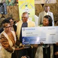 Chairperson receiving award from deputy minister and Vumelana