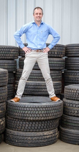 Dr Mehran Zarrebini stand on a pile of truck tyres waiting to be recycled at the Mathe Group factory in Hammarsdale.