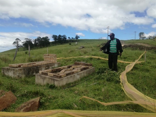 Msikaba Cabela stands next to some of his family graves which he says are cracking. Photo: Thembela Ntongana