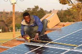 Lamo Solar CEO Tshibvumo Sikhwivhilu, a participant in the Eskom Contractor Academy, installing solar panels.