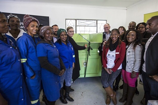 Serioplast administration and finance manager Leigh Fitzpatrick cuts the ribbon on a new baling machine under the watchful eye of PETCO chairman Casper Durandt (back, right) and representatives from beneficiary organisation CJU Environmental Management (in blue uniforms), as well as partners PETCO and the City of Ekurhuleni.