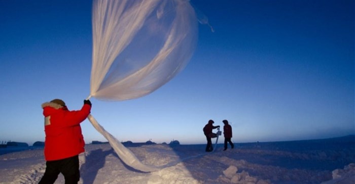 Researchers release a balloon carrying instruments to measure ozone levels above Antarctica. ,
