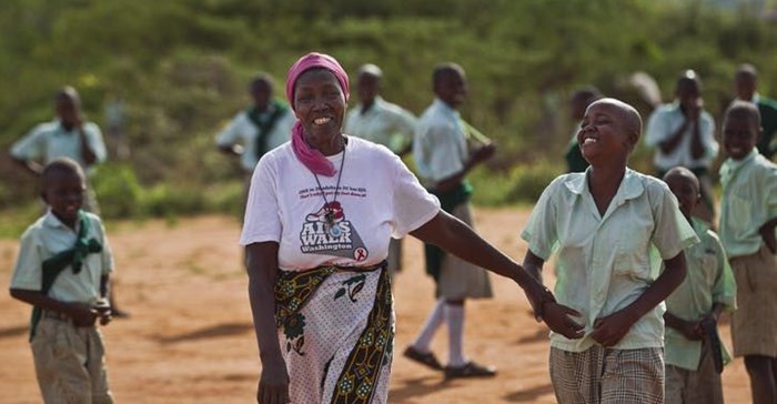 In this 2012 photo, grandmother Janet Kitheka, 63, collects her adopted “granddaughter” Lucy, 13, at the end of the school day in the yard of the Hot Courses Primary School, in the village of Nyumbani which caters to children who lost their parents to HIV, and grandparents who lost their children to HIV in Kenya.