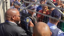 Mineral Resources Minister Gwede Mantashe talks to protesters through the locked gates of the Uitkyk Community Hall in Lutzville on Friday. Photo: John Yeld