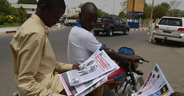 A man reads a newspaper in a street in N'Djamena, Chad, on April 12, 2016. A publisher was recently handed a suspended jail term in a defamation suit involving the president's brother. Credit: CPJ/cIssouf Sanogo/AFP.