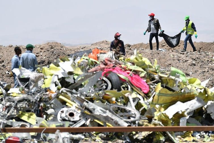 A crew works with an investigative team to clear the crash site of a Boeing 737 Max 8 operated by Ethiopian Airlines. All 8 crew and 149 passengers died in the March 10 accident. Tony Karumba/AFP