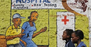 Women walk past a mural painted to raise awareness on HIV and AIDS in Kibera slum in Nairobi, Kenya. EPA/Dai Kurokawa