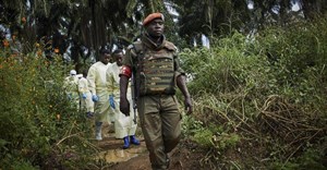 Congolese National Army solider escorts health workers to the grave of an Ebola victim, in Beni, North Kivu province. EPA-EFE/HUGH KINSELLA CUNNINGHAM