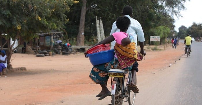 A woman and baby on a bicycle taxi in Salima, Malawi. Some Malawian men are becoming more involved in childcare. EPA-EFE