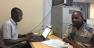 Hamza Idris (left), an editor with the Daily Trust newspaper, sits with colleague Hussaini Garba Mohammed in their office in the Nigerian capital, Abuja, in February 2019. The office was raided in January by the military, who seized 24 computers. Credit: CPJ/Jonathan Rozen.
