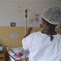 A nurse in a hospital checks an IV. Wikimedia Commons