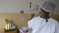 A nurse in a hospital checks an IV. Wikimedia Commons
