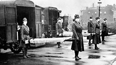 The St Louis Red Cross Motor Corps on duty with mask-wearing women holding stretchers at the backs of ambulances during the global flu epidemic, St Louis, Missouri, October 1918.
Photo by Underwood Archives/Getty Images