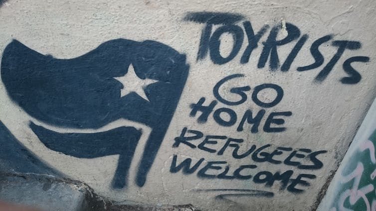 Graffiti in Barcelona: 'Tourists go home. Refugees welcome.' ,