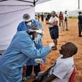 A healthcare worker collecting a swab for a Covid-19 test from a community member. AFP via Getty Images