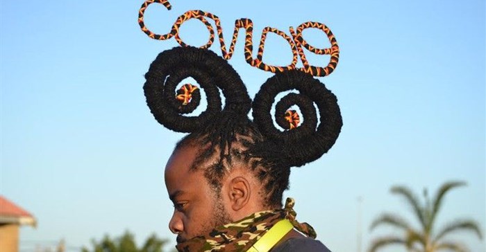 Hair stylist Onele Cembi twists his dreadlocks into the words “Covid-19”. Photo: Thamsanqa Mbovane