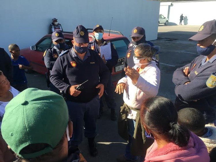 Police speak to protesters in Hout Bay harbour on Tuesday. Photo: James Stent