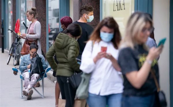 Shoppers line up in front of a Zara clothing store waiting for the opening after being closed for nearly two months in Montréal on May 25, 2020. The Canadian Press/Paul Chiasson