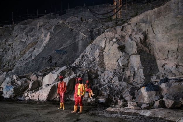 Construction workers stand next to rock wall at the Grand Ethiopian Renaissance Dam in Ethiopia on December 26, 2019.
