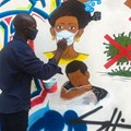 Congolese artist Chris Shongo paints on the outside wall of the Academie des Beaux-Arts in Kinshasa on June 18, 2020.
