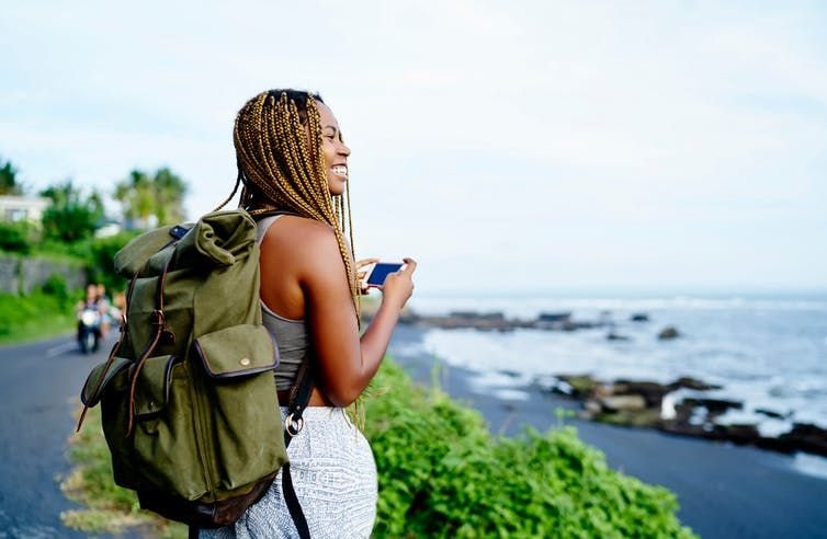 https://www.shutterstock.com/image-photo/cheerful-dark-skinned-female-traveller-holding-1281959434