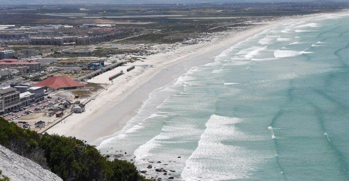 Muizenberg beach is eerily quiet on a hot summer’s day, 29 December 2020. If we want to save lives and life to go back to normal we need to embrace vaccines.
