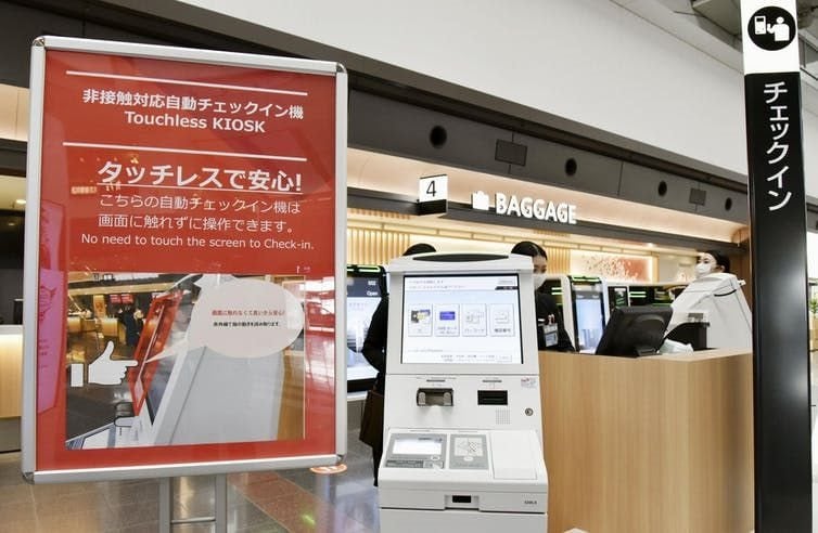 New self-service check-in machines introduced by Japan Airlines at Tokyo’s Haneda airport enable passengers to complete the procedure without touching the screen. Kyodo/AP