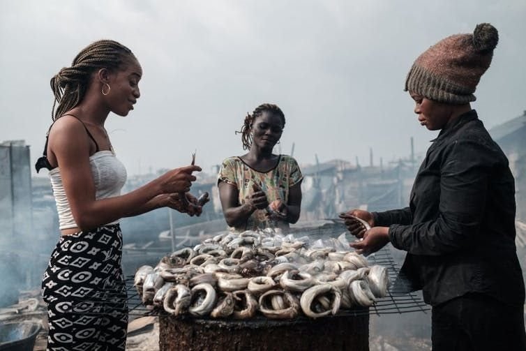 Women make smoked fishes - locally called Okporoko - at Egede informal settlement in Port Harcourt, Nigeria. YASUYOSHI CHIBA/AFP via Getty Images