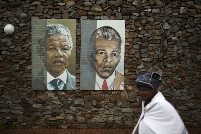 A woman walks past portraits of former South African President Nelson Mandela at the end of a memorial service in the Nelson Mandela Museum in Qunu on 10 December 2013. Reuters/Siegfried Modola/File Photo